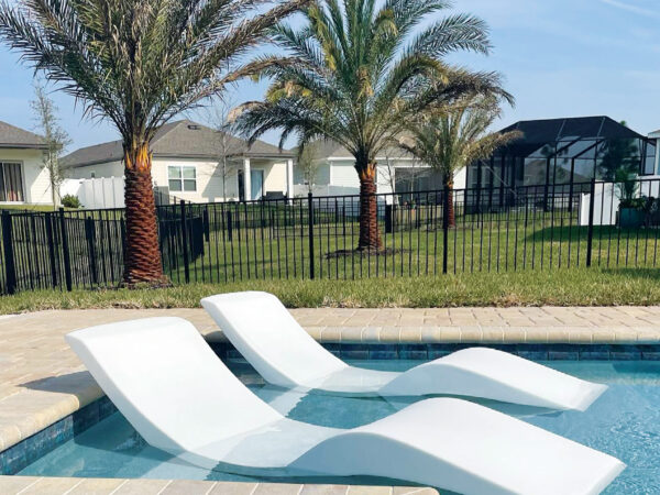 Aqua Outdoor chaise loungers in the pool on a tanning ledge.