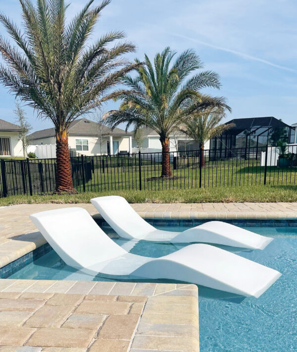 Aqua Outdoor chaise loungers in the pool on a tanning ledge.